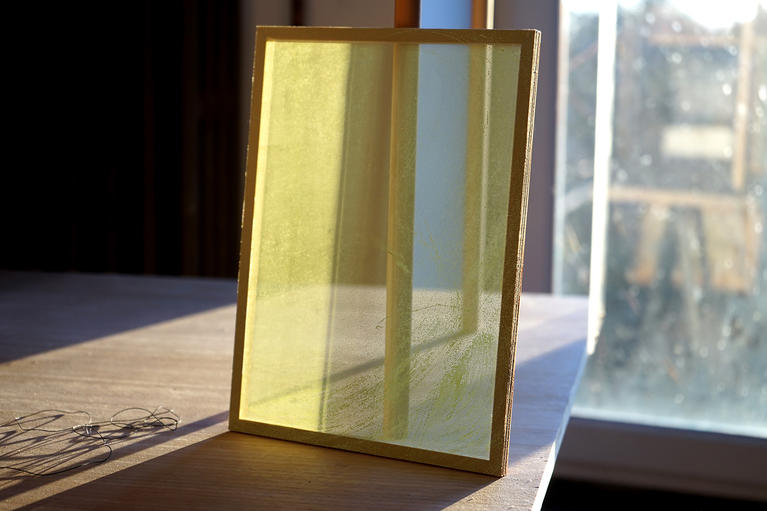 Oeuvre de Cécile Bart prise en photo dans la lumière : peinture jaune sur toile transparente tendue
