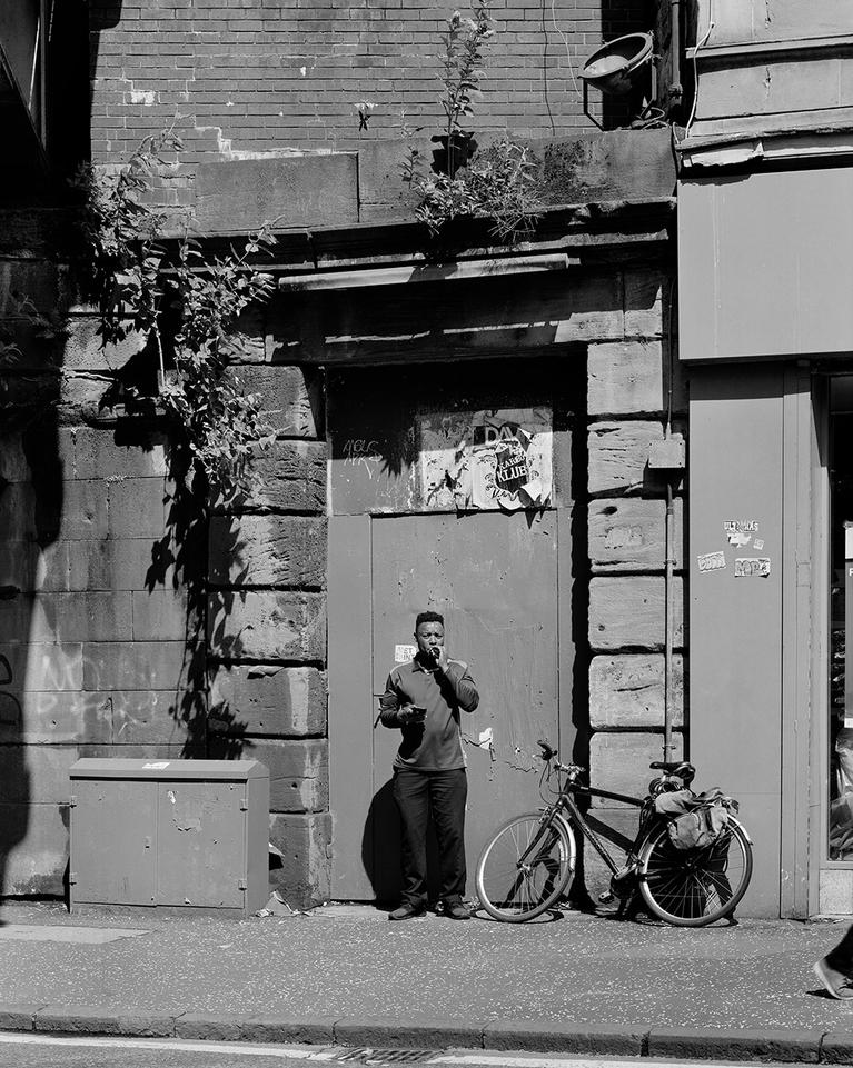 FALLET Camille, Man waiting for a delivery in front of an old entrance along railway bridge, Dubarton Road, Glasgow, 2019