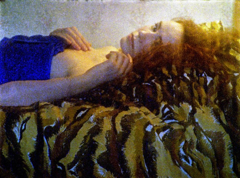 Capture d'écran du film CAT EFFEKT de Distruktur - une femme est allongé sur un lit et regarde l'objectif